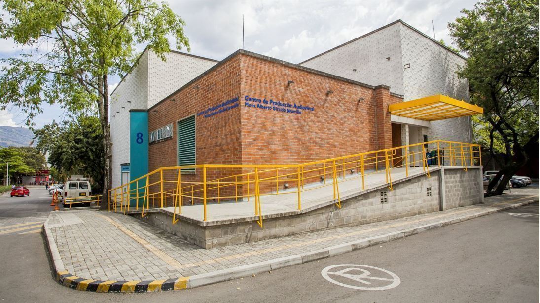 Fachada externa del Centro de Producción Audioviosual, edificio de dos pisos, con fachada en ladrillo y rampa de acceso.