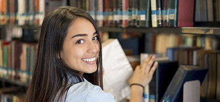 estudiante buscando libro en la Biblioteca