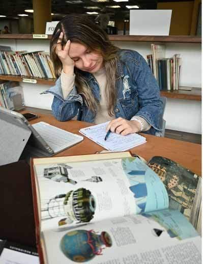 estudiante en biblioteca estresada