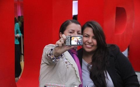 Egresadas posando para una selfie a la entrada del encuentro frente a las letras UPB