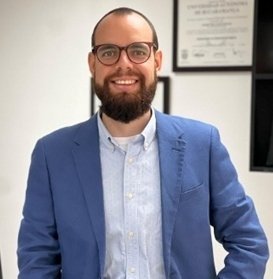 Hombre con chaqueta azul posando para una fotografía