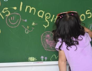 Niña dibuja en el nuevo tablero de la Clínica Noel