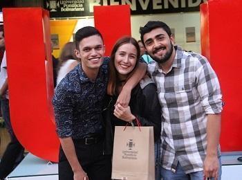 Egresados posando para una foto frente a las letras UPB