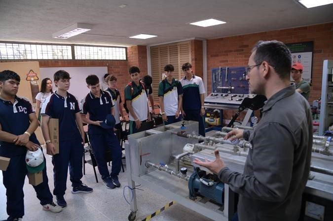 Estudiantes en un aula de clase revisando proyectos